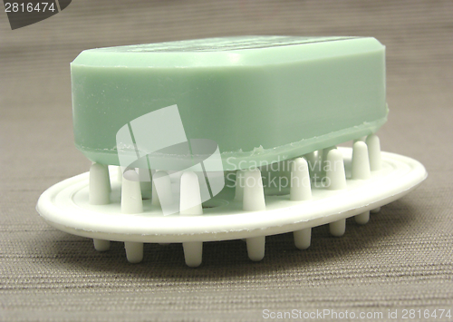 Image of Green soap on a soap dish on a gray  background