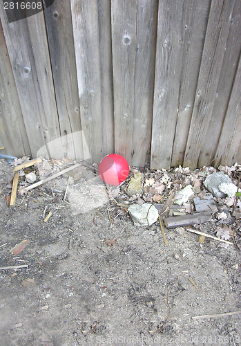 Image of Red balloon in front of a weathered timber wall