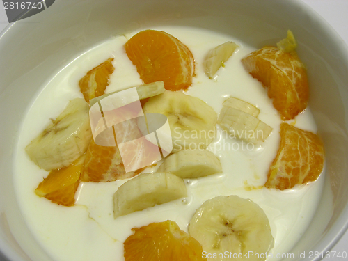 Image of Yoghurt with banana cutted into pieces and tangerine