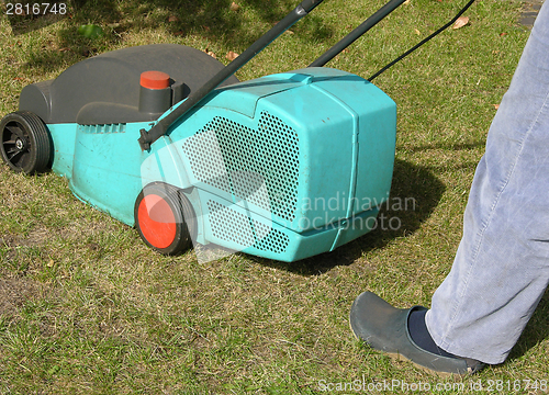 Image of Cutout man with lawn mower doing his work