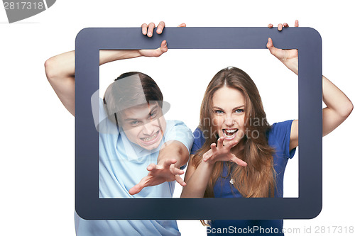 Image of Happy couple looking through tablet frame