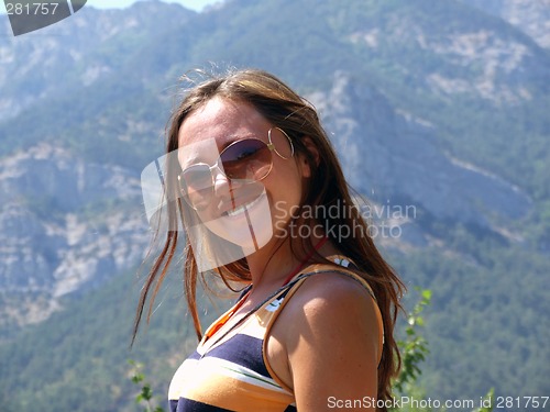 Image of Portrait of the young beautiful girl on a background of mountain