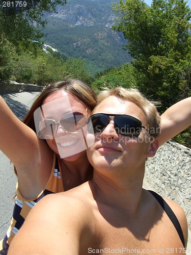 Image of Portrait of young pair in sunglasses on mountain road