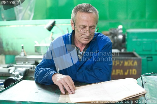 Image of Elderly worker looks in drawing