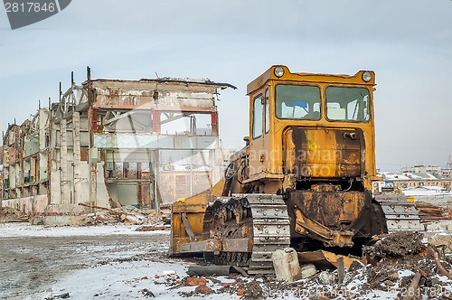 Image of Bulldozer in front of old industrial building