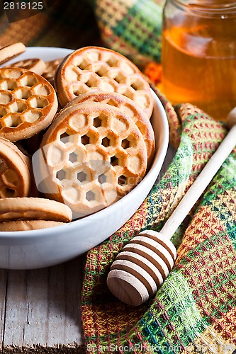 Image of fresh cookies in a bowl, tablecloth and honey 