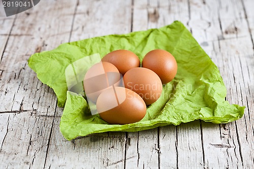 Image of  fresh brown eggs on green napkin 