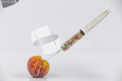 Image of Peach and syringe with pills