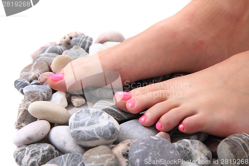 Image of womens legs (nails) and stones (pedicure)