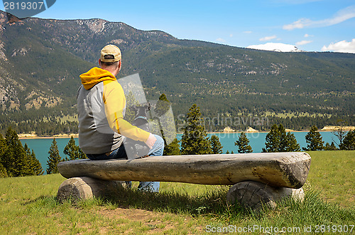 Image of Man and chihuahua on a bench