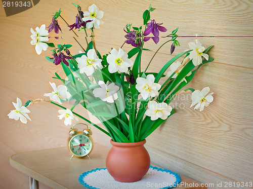 Image of Blossoming narcissuses in a vase on a table.