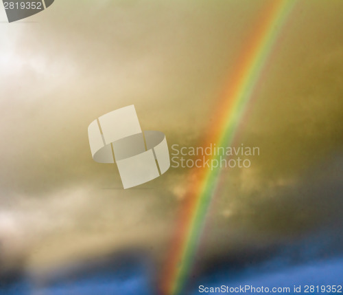 Image of Thunderclouds and rainbow in the sky.