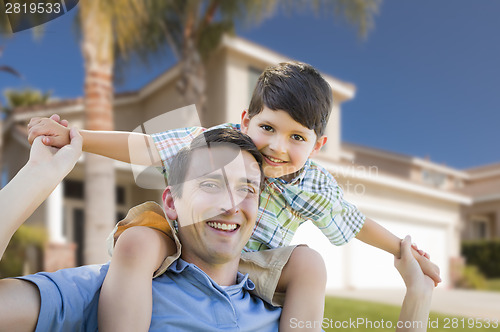 Image of Mixed Race Father and Son Piggyback in Front of House