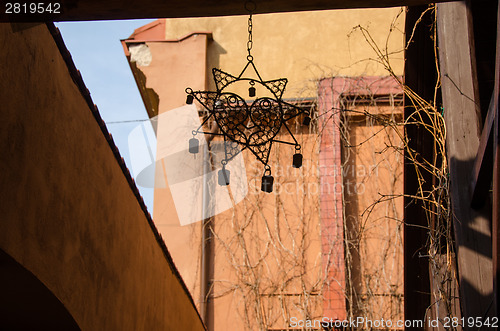 Image of decorative sun shaped pendant outdoor at cafe 