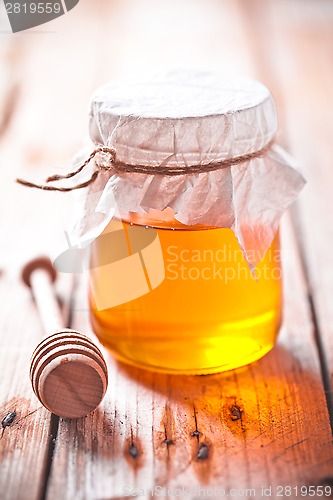 Image of full honey pot and honey stick 