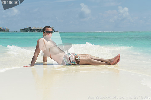 Image of young man have fun and relax on beach