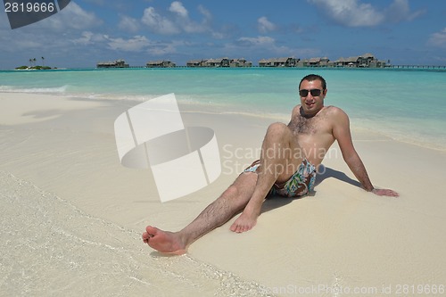 Image of young man have fun and relax on beach