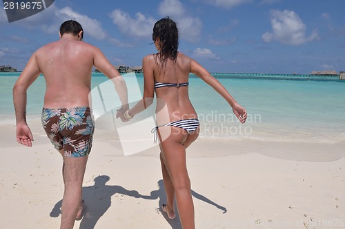 Image of happy young couple have fun on beach