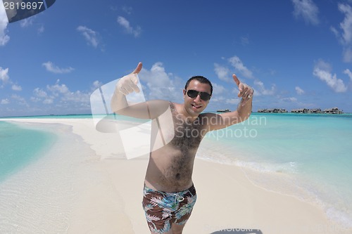 Image of young man have fun and relax on beach