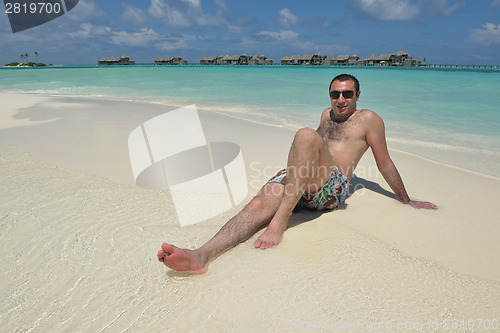 Image of young man have fun and relax on beach