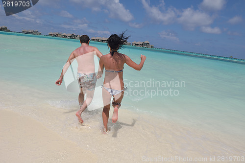 Image of happy young couple have fun on beach