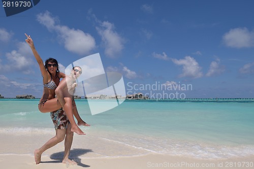 Image of happy young couple have fun on beach