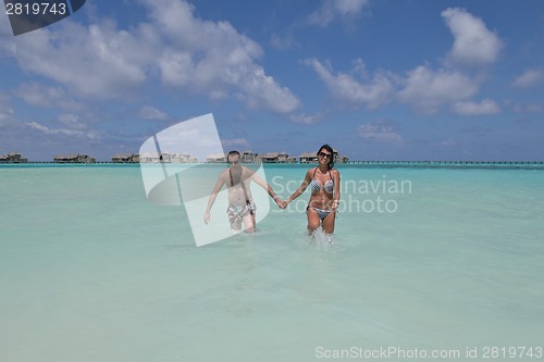 Image of happy young couple have fun on beach