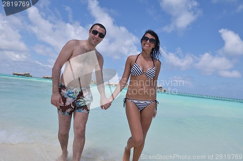 Image of happy young couple have fun on beach