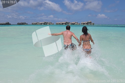 Image of happy young couple have fun on beach