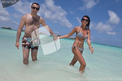 Image of happy young couple have fun on beach