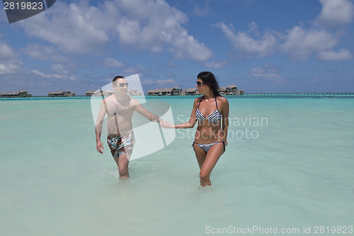 Image of happy young couple have fun on beach