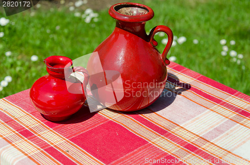 Image of large and small red retro vintage clay jugs