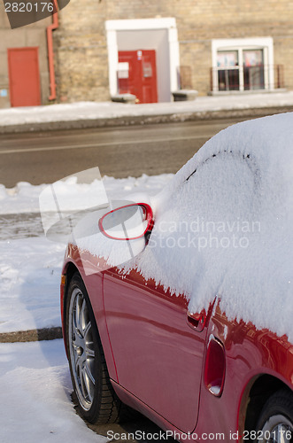 Image of close up of car side covered with snow in parking 