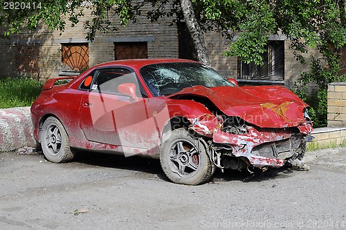 Image of The red broken car after accident.