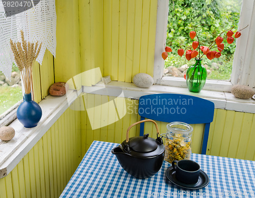 Image of village kitchen and healing calendula tea on table 