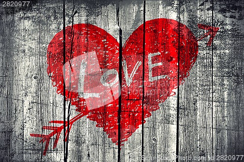 Image of Drawing of a heart with word "Love" on grunge wooden wall backgr