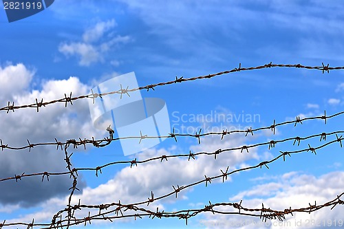 Image of Barbed wire against blue sky