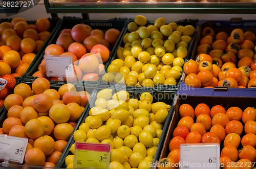 Image of fresh orange lemon persimmon in plastic boxes  