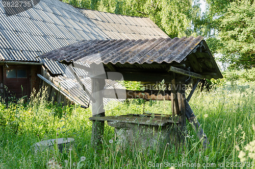 Image of old derelict rural manhole covered with tall grass 