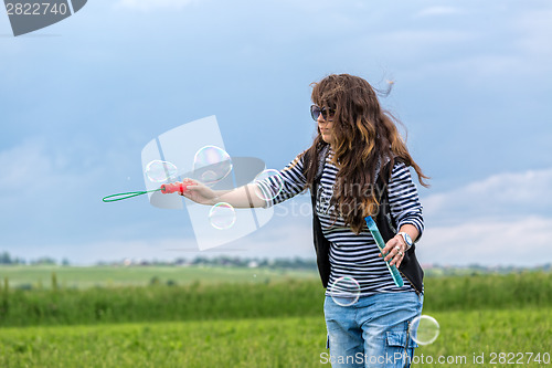 Image of Beautiful Young Woman make Blowing Bubbles