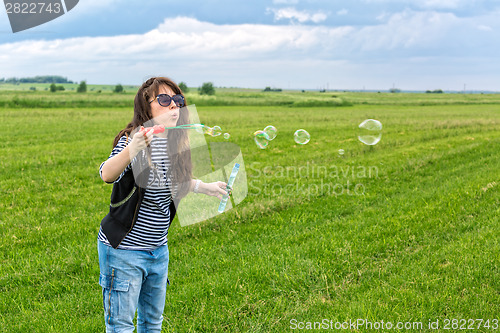 Image of Beautiful Young Woman make Blowing Bubbles