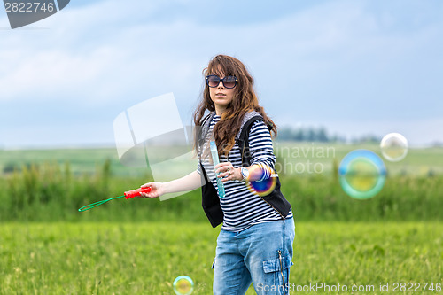 Image of Beautiful Young Woman make Blowing Bubbles