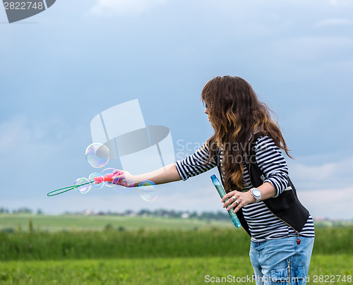 Image of Beautiful Young Woman make Blowing Bubbles