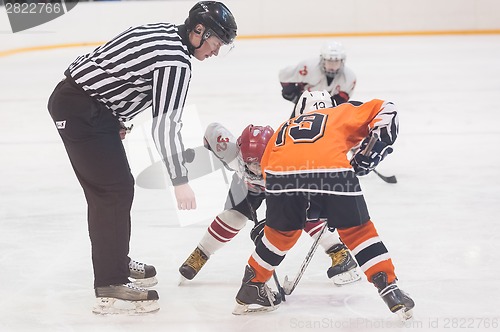 Image of Puck playing between players of ice-hockey teams