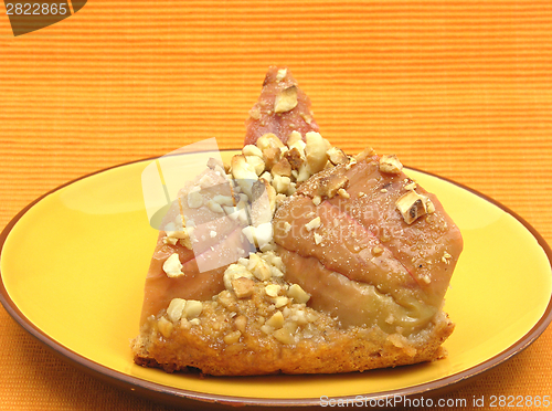 Image of One slice of a wholemeal apple cake on orange placemat