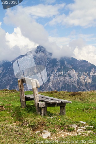 Image of Wooden bench and in the background the Austrian Alps