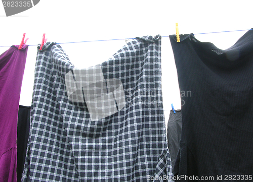 Image of Clothesline  with some laundered clothes on white