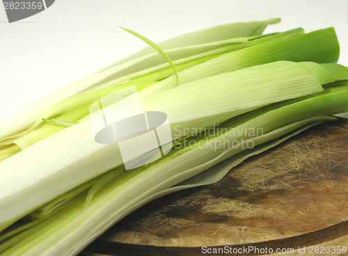 Image of Green leek on a wooden plate in a  close-up view