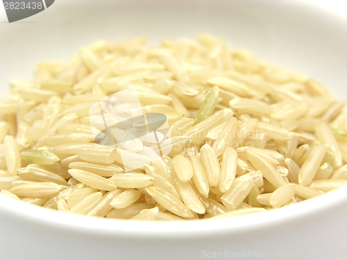 Image of Brown rice in a bowl of chinaware on a white background