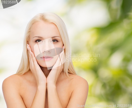 Image of face of beautiful woman touching her face skin